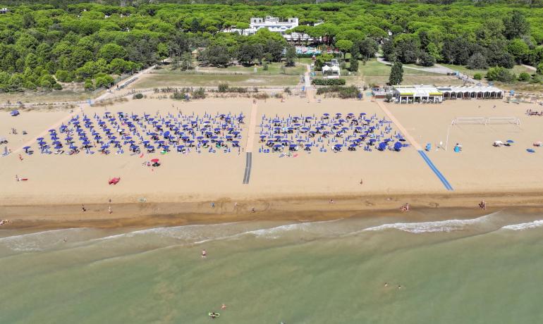 Beach with blue umbrellas and calm sea.