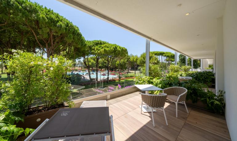 Terrace with pool and tree view, modern furniture.