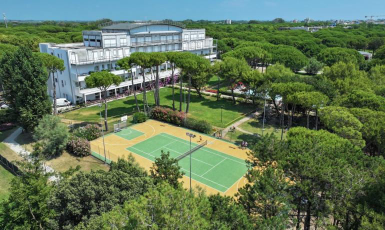 Aerial view of a building with sports court and gardens.